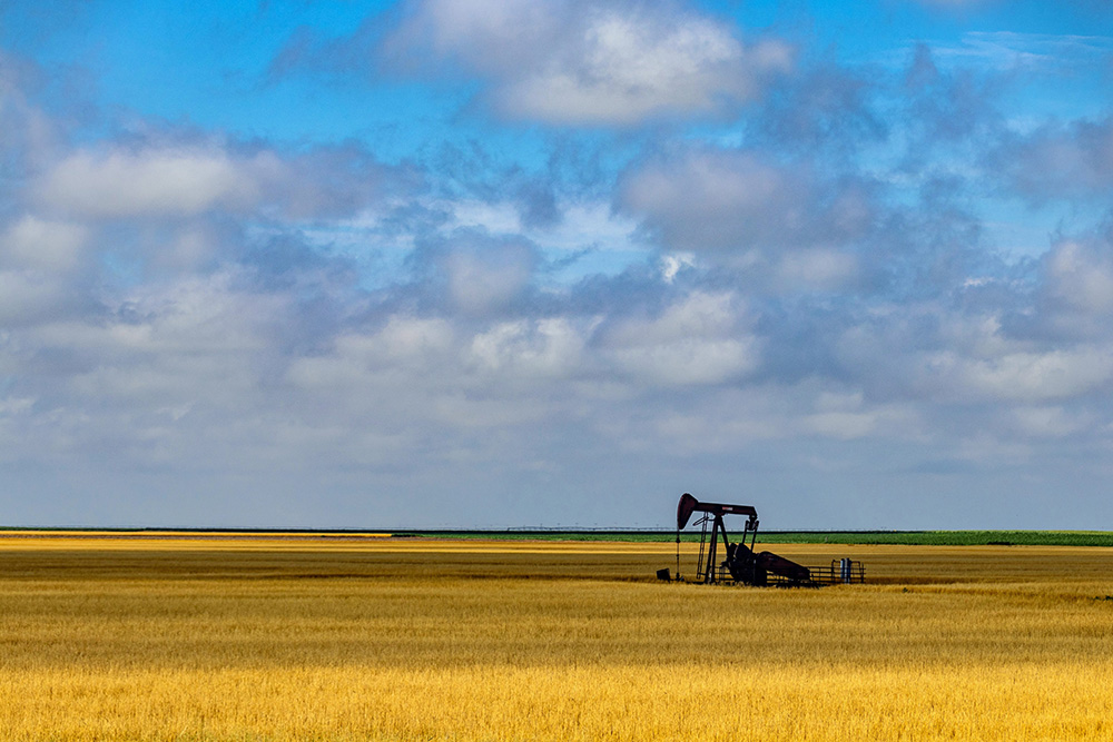 Golden wheat field with pumpjack under Kansas sky